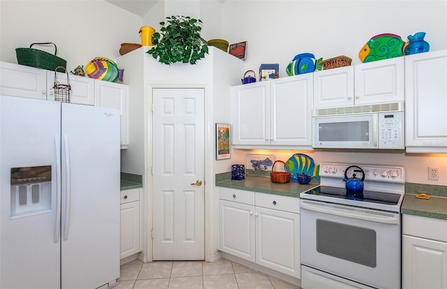 kitchen featuring white cabinets, light tile patterned flooring, and white appliances