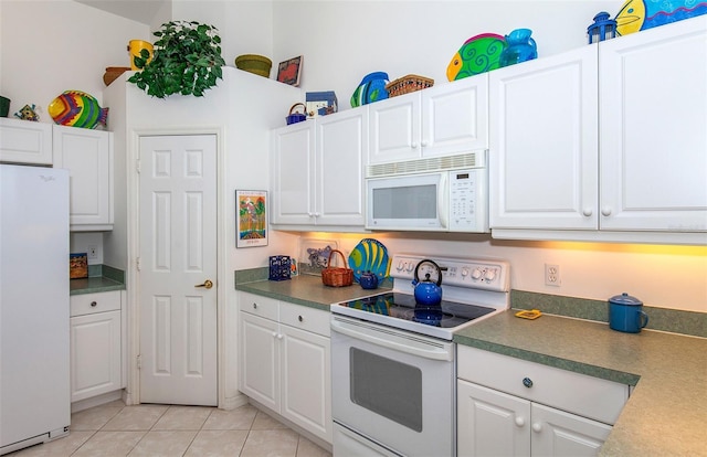 kitchen with white appliances, white cabinetry, and light tile patterned floors