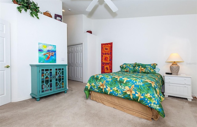 bedroom featuring ceiling fan, a closet, light carpet, and high vaulted ceiling