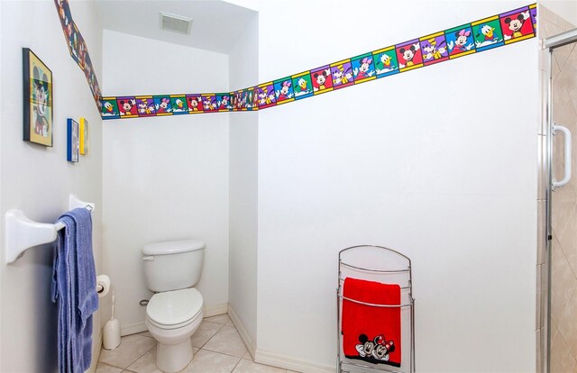 bathroom featuring a shower with door, tile patterned floors, and toilet