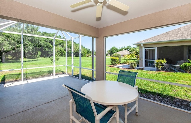 sunroom featuring outdoor dining area and a ceiling fan