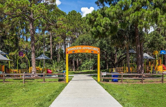view of community with a lawn, fence, and playground community