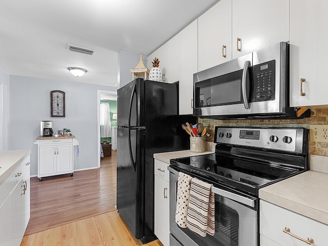 kitchen featuring white cabinetry, backsplash, light hardwood / wood-style floors, and appliances with stainless steel finishes