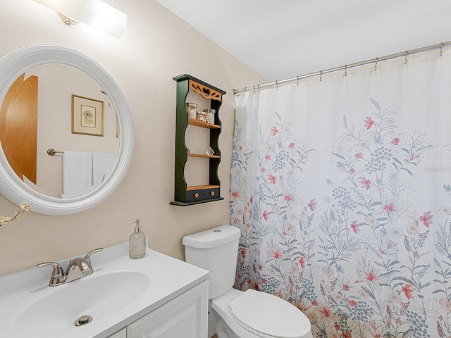 bathroom featuring vanity, toilet, and walk in shower