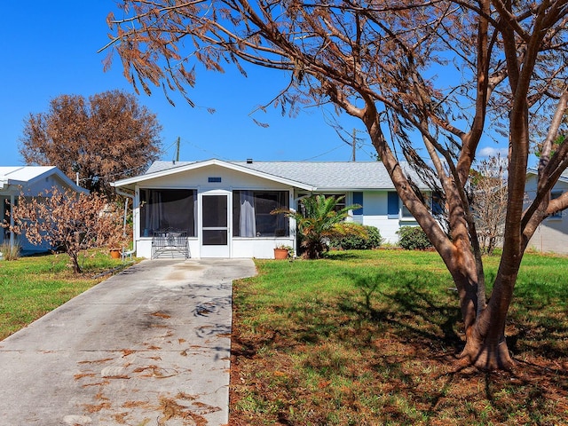 ranch-style home featuring a sunroom and a front yard