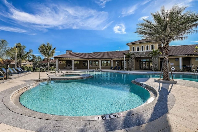 view of swimming pool featuring a community hot tub and a patio