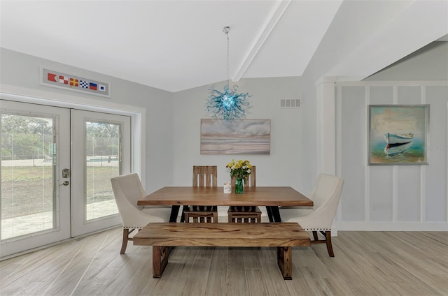 dining room featuring vaulted ceiling with beams, french doors, and light hardwood / wood-style flooring