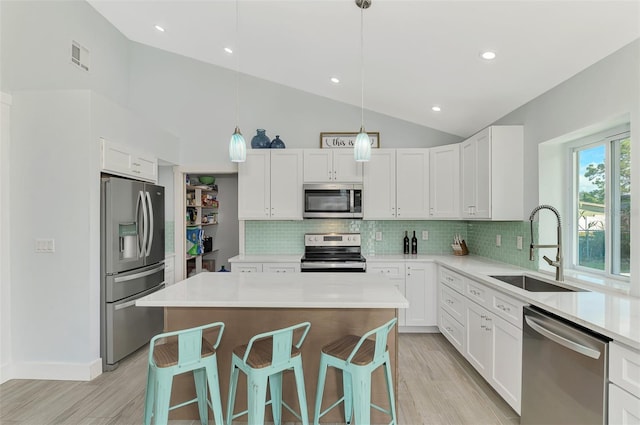 kitchen with white cabinetry, a breakfast bar, a kitchen island, and stainless steel appliances