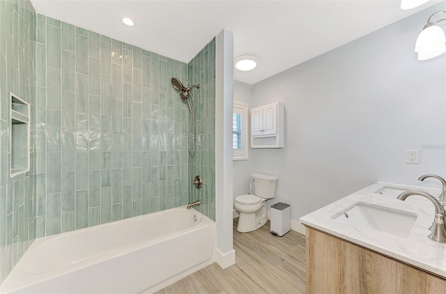 full bathroom featuring toilet, vanity, tiled shower / bath combo, and hardwood / wood-style flooring