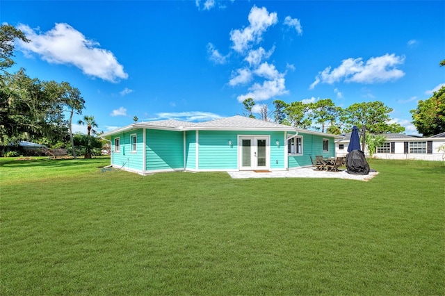 rear view of property featuring a lawn and french doors