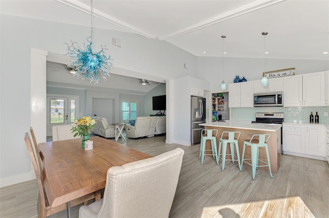 dining space featuring beamed ceiling, high vaulted ceiling, light hardwood / wood-style flooring, and ceiling fan