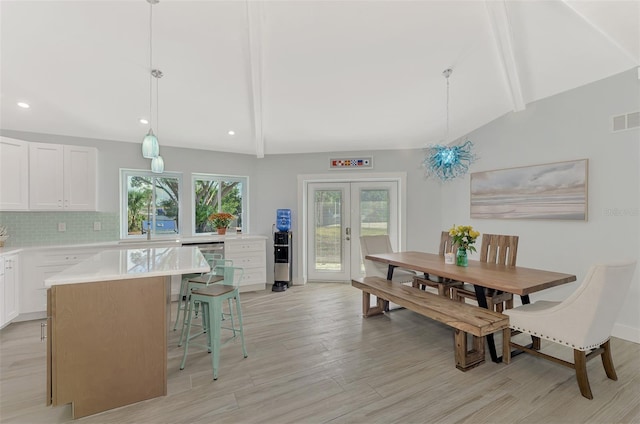 dining room with vaulted ceiling with beams, french doors, and light hardwood / wood-style floors