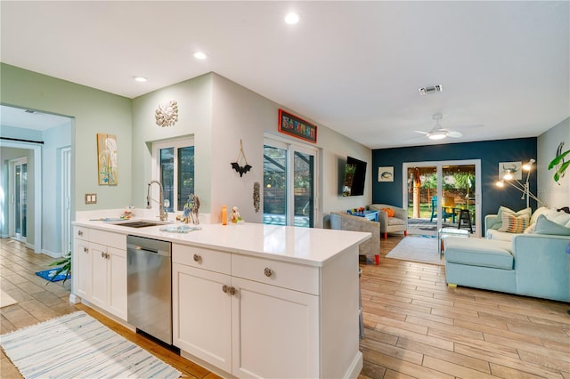 kitchen with dishwasher, white cabinets, light wood-type flooring, and a wealth of natural light