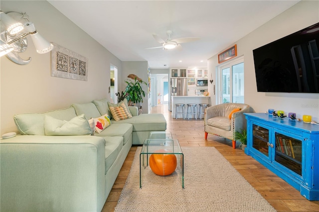 living room featuring light wood-type flooring and ceiling fan