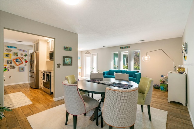 dining room featuring a textured ceiling and light wood-type flooring