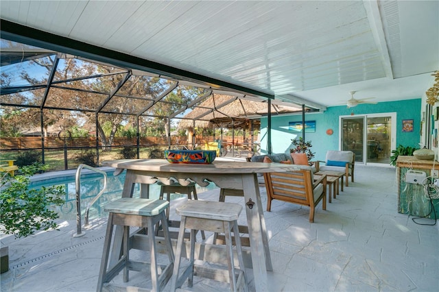 view of patio with outdoor lounge area, ceiling fan, and a lanai