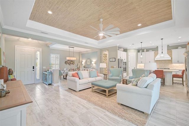 living room with ceiling fan with notable chandelier, wooden ceiling, crown molding, and a raised ceiling