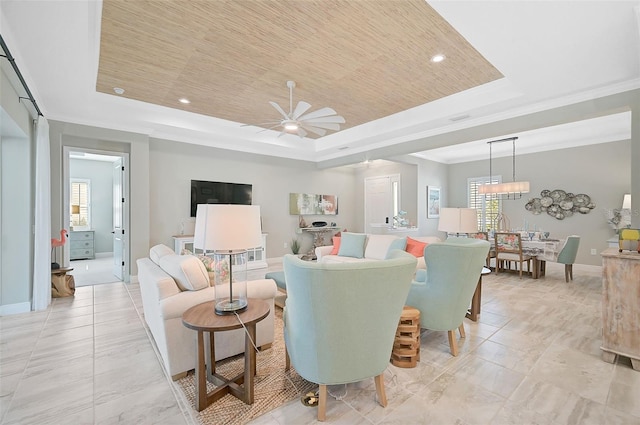 living room featuring a tray ceiling and a healthy amount of sunlight