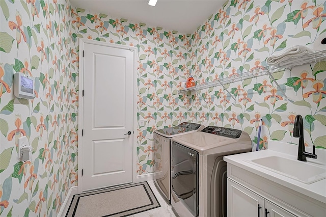 laundry room featuring independent washer and dryer, cabinets, and sink