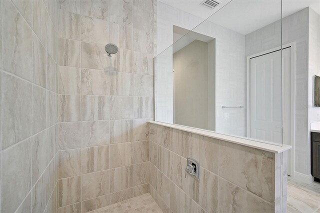 bathroom featuring vanity and a tile shower