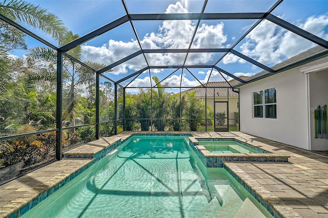 view of swimming pool with glass enclosure, an in ground hot tub, and a patio area