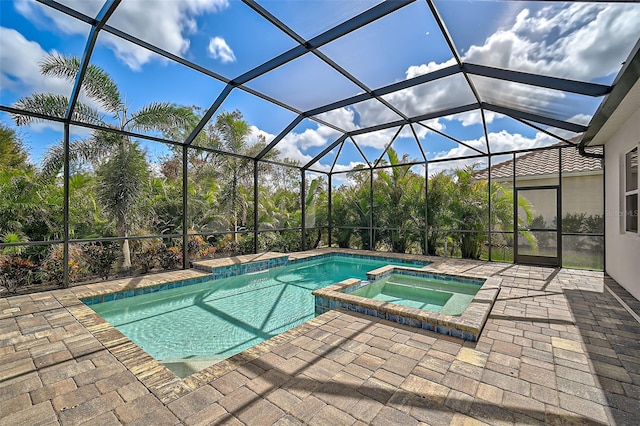 view of swimming pool featuring a patio, a lanai, and an in ground hot tub