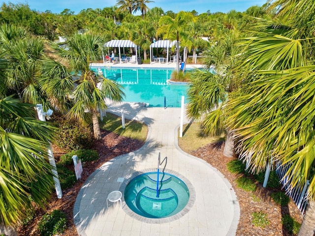 view of pool with a hot tub and a patio area