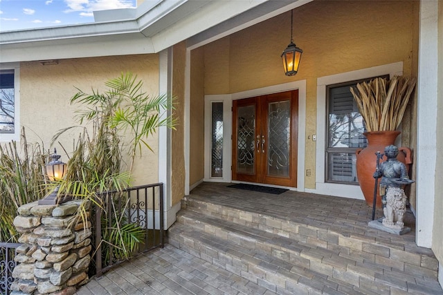view of exterior entry with french doors and stucco siding