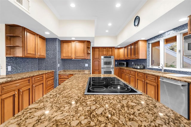 kitchen with stainless steel appliances, visible vents, open shelves, brown cabinetry, and light stone countertops