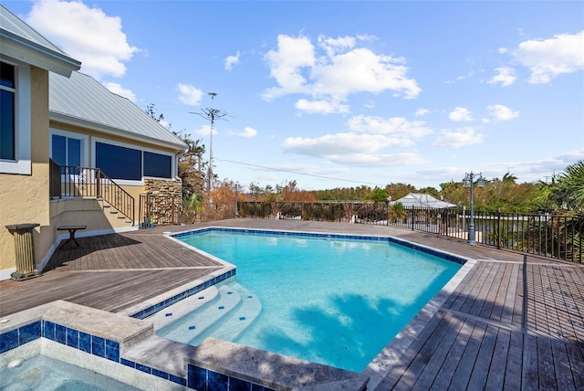 view of swimming pool with a wooden deck and an in ground hot tub