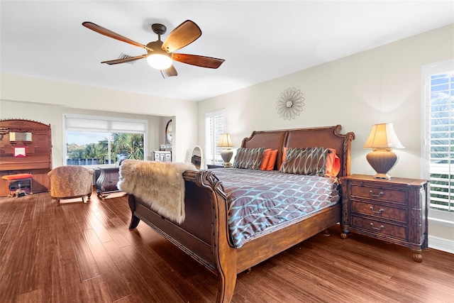 bedroom with hardwood / wood-style floors, multiple windows, and ceiling fan