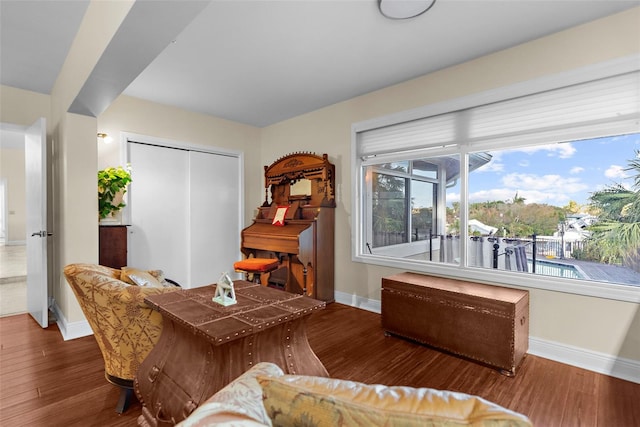 living area with wood finished floors, a wealth of natural light, and baseboards