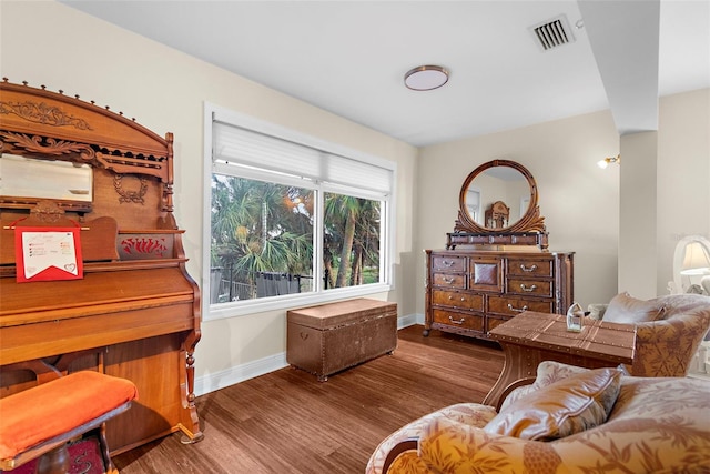 living area featuring baseboards, wood finished floors, and visible vents