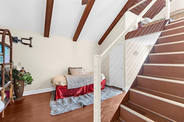 bedroom featuring lofted ceiling with beams, baseboards, and wood finished floors