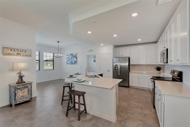 kitchen featuring white cabinets, stainless steel appliances, sink, and an island with sink