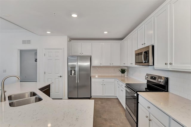 kitchen featuring stainless steel appliances, sink, light tile patterned floors, white cabinetry, and light stone counters