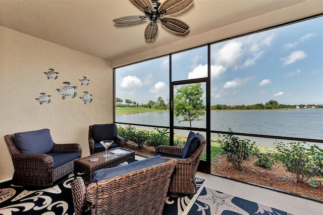 sunroom featuring a water view and ceiling fan