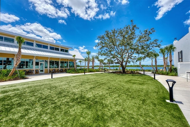 surrounding community featuring a water view and a lawn