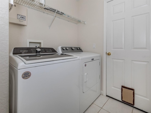 laundry room with light tile patterned flooring and washing machine and clothes dryer