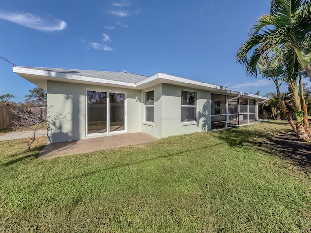 rear view of property featuring a sunroom, a lawn, and a patio area