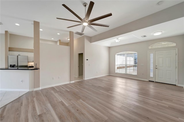 unfurnished living room with ceiling fan and light hardwood / wood-style flooring