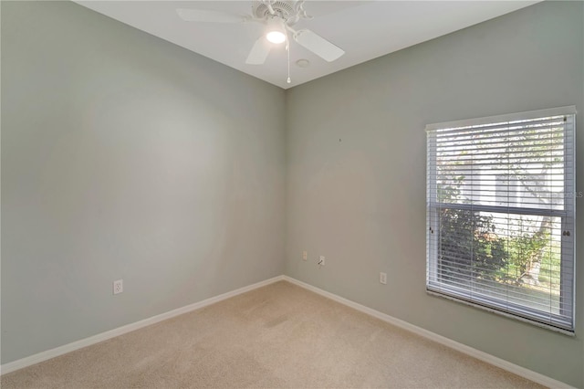 carpeted spare room with ceiling fan