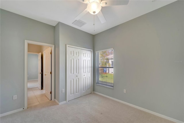 unfurnished bedroom featuring light carpet, a closet, and ceiling fan