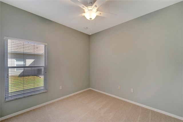 carpeted spare room featuring ceiling fan