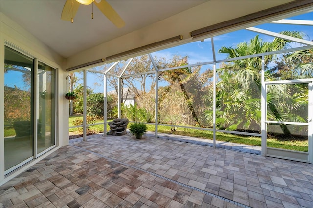 unfurnished sunroom featuring ceiling fan and a healthy amount of sunlight