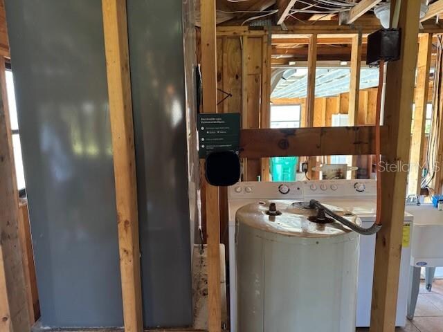 utility room featuring washer / dryer and water heater