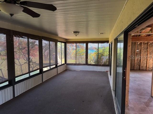 unfurnished sunroom with ceiling fan