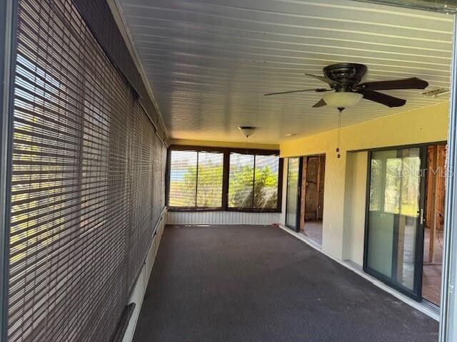 unfurnished sunroom with ceiling fan