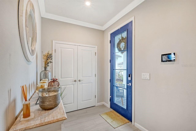 entryway with ornamental molding and light wood-type flooring