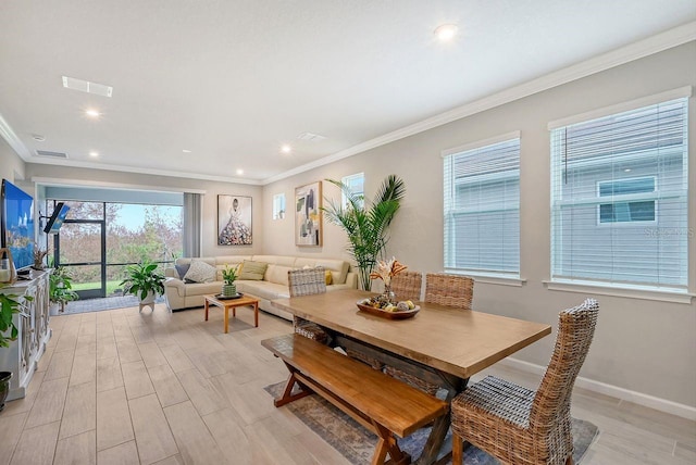 dining room with ornamental molding and light hardwood / wood-style flooring